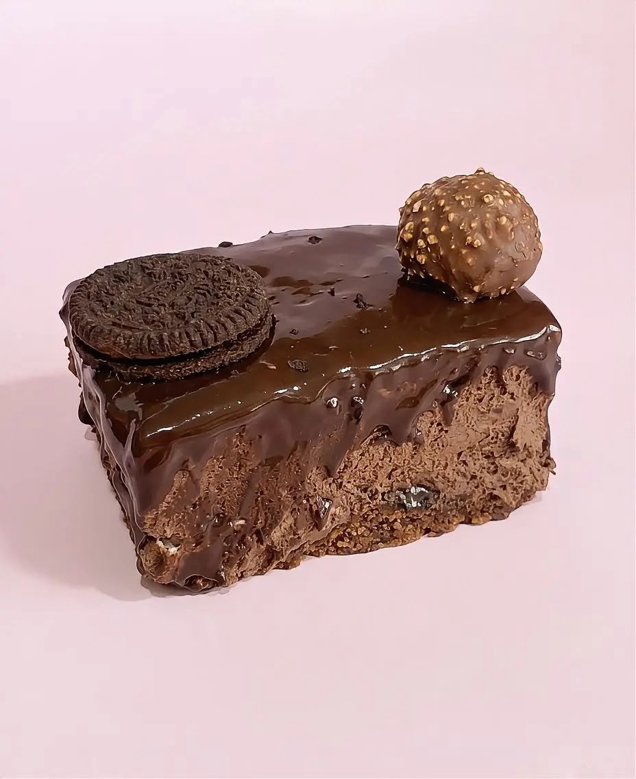 Square slice of chocolate mousse cake with glossy drip glaze